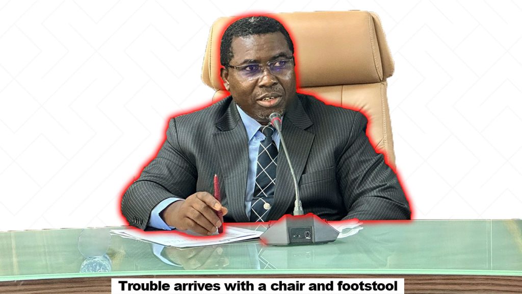 an image of Amupitan sitting on a chair with a pen and paper