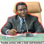 an image of Amupitan sitting on a chair with a pen and paper